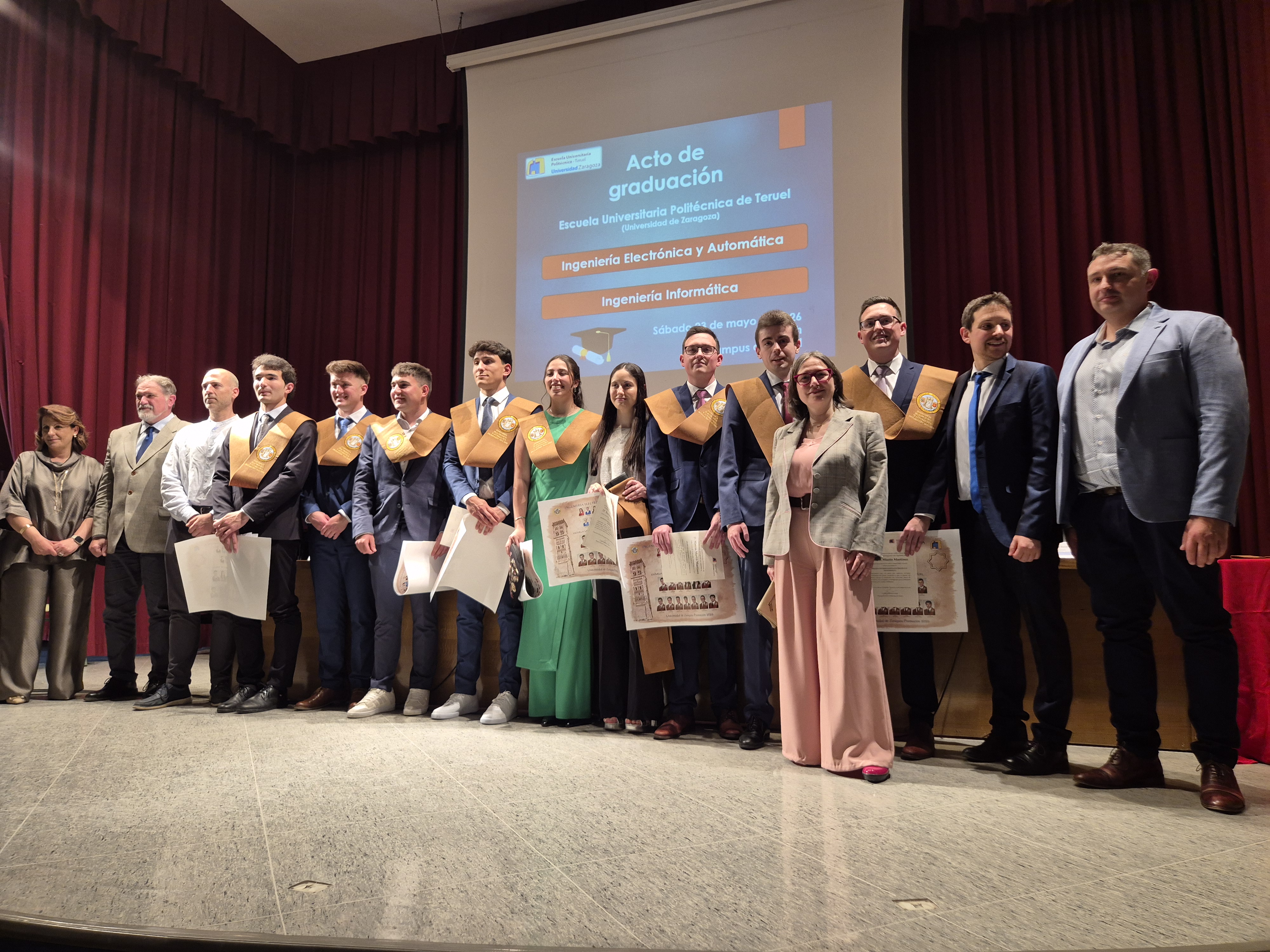 Estudiantes graduados en Ingeniería Electrónica y Automática con madrina, rectora, director, durante la graduación en la Escuela Universitaria Politécnica de Teruel